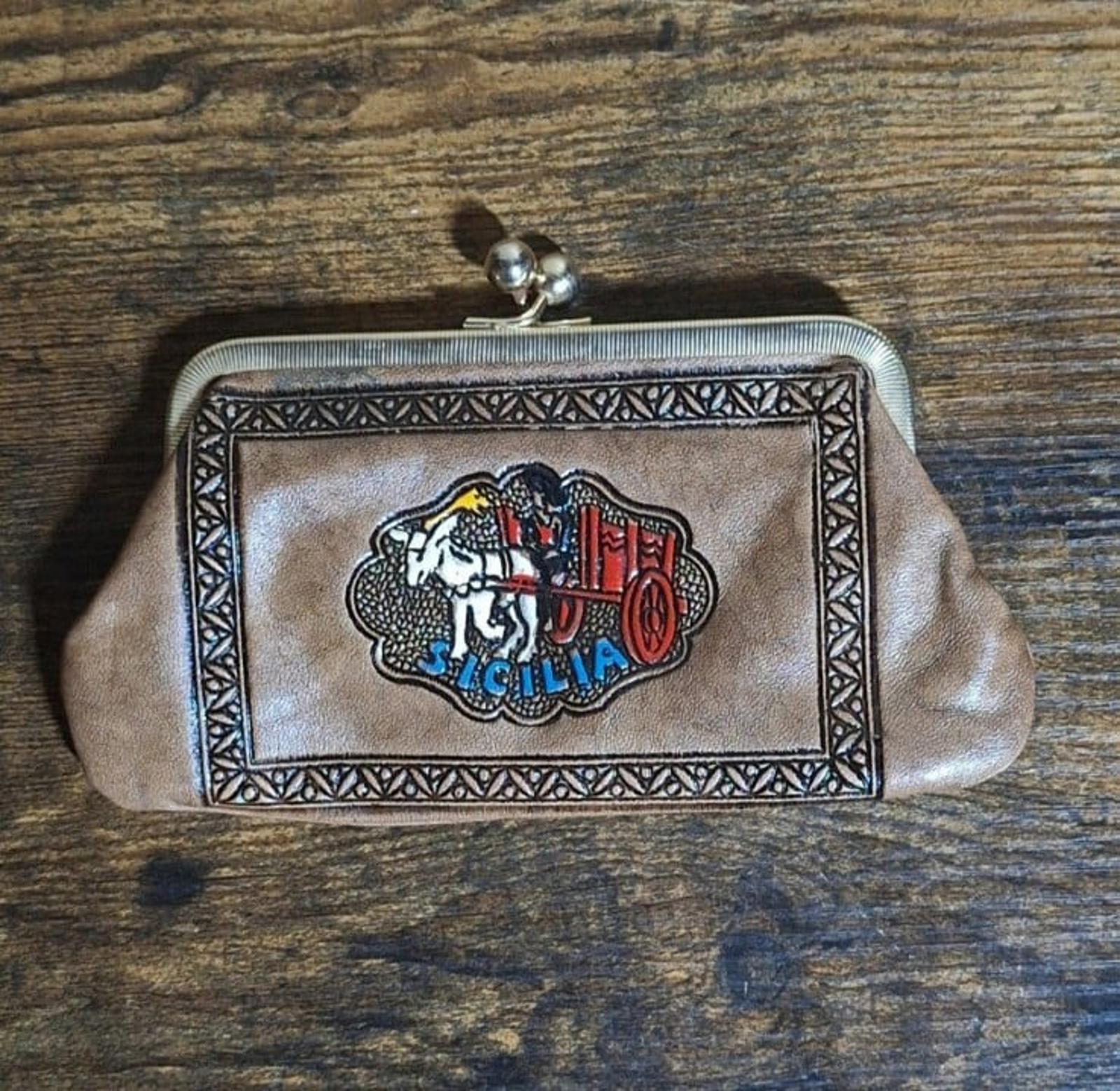 Tan leather coin purse wallet with Sicily crest emblem on front panel and metal frame.