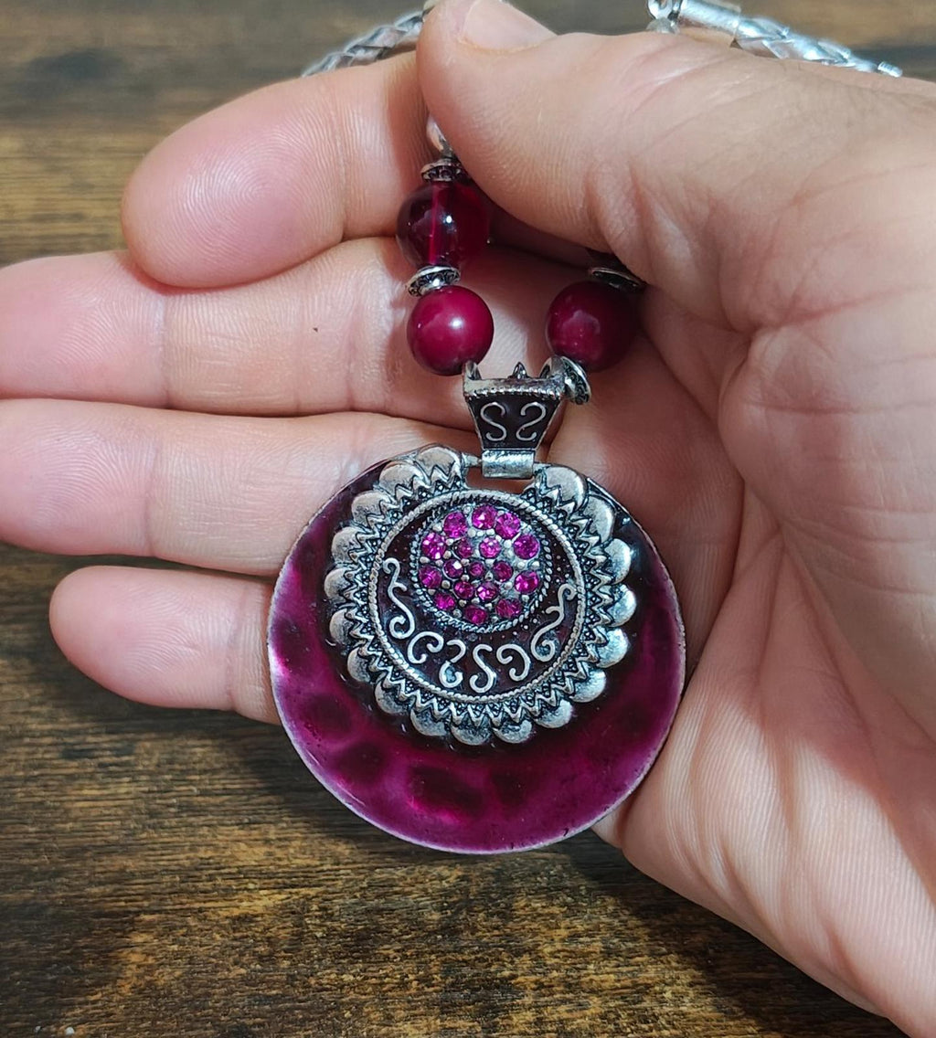 Round burgundy pendant necklace with ornate silver frame and pink bead drops