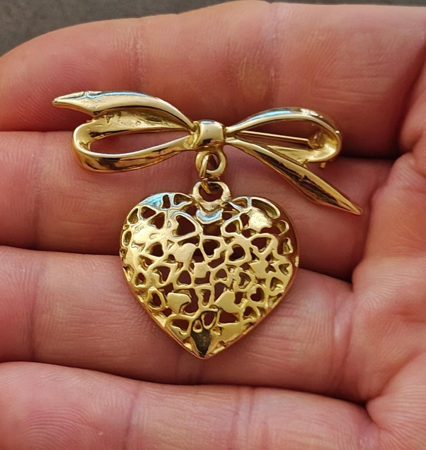 80s Gold Tone Ribbon Bow Brooch With a Dangling Openwork Filigree Heart Pendant