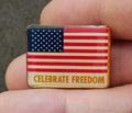 Gold-tone rectangular patriotic flag pin with “CELEBRATE FREEDOM” text