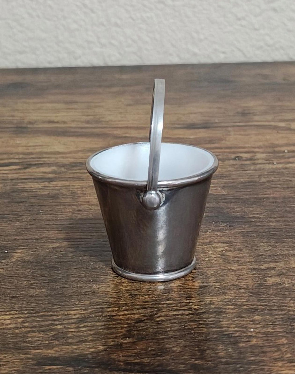 Mini silverplated bucket pail with vertical handle bar and white interior