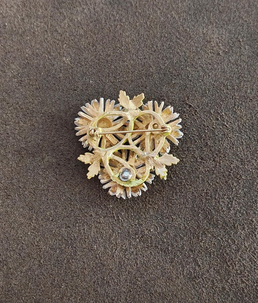 Gold-tone daisy brooch back with filigree metalwork and small light-blue stone