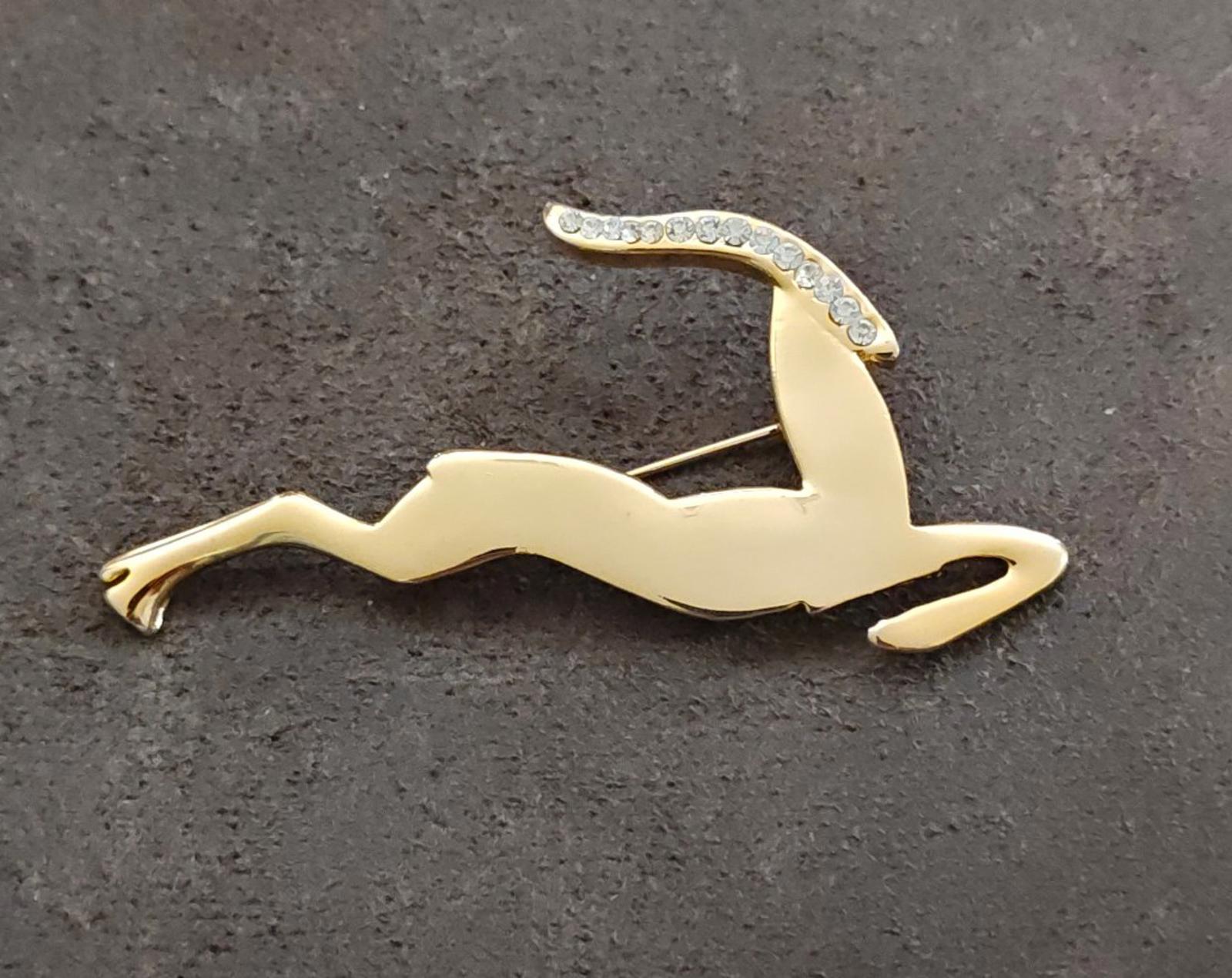 Gold-tone leaping gazelle/impala brooch with sparkling rhinestone accents, angled view