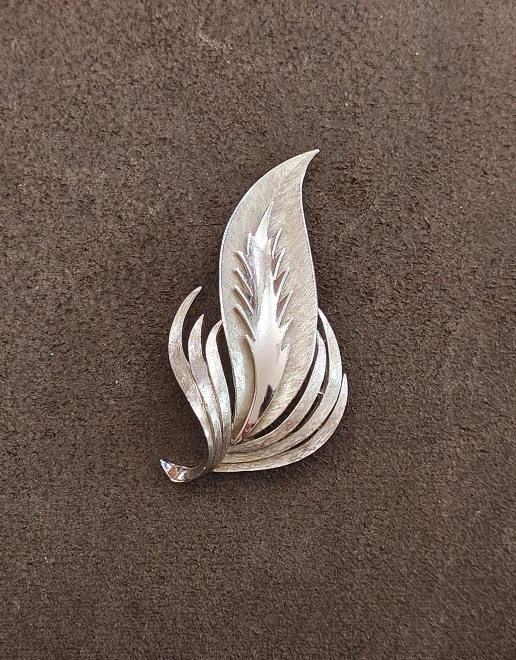 Silver-tone leaf brooch with curved pointed feather leaves, detailed front