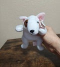 White plush dog with brown ear patch and red Ty heart tag, held in hand