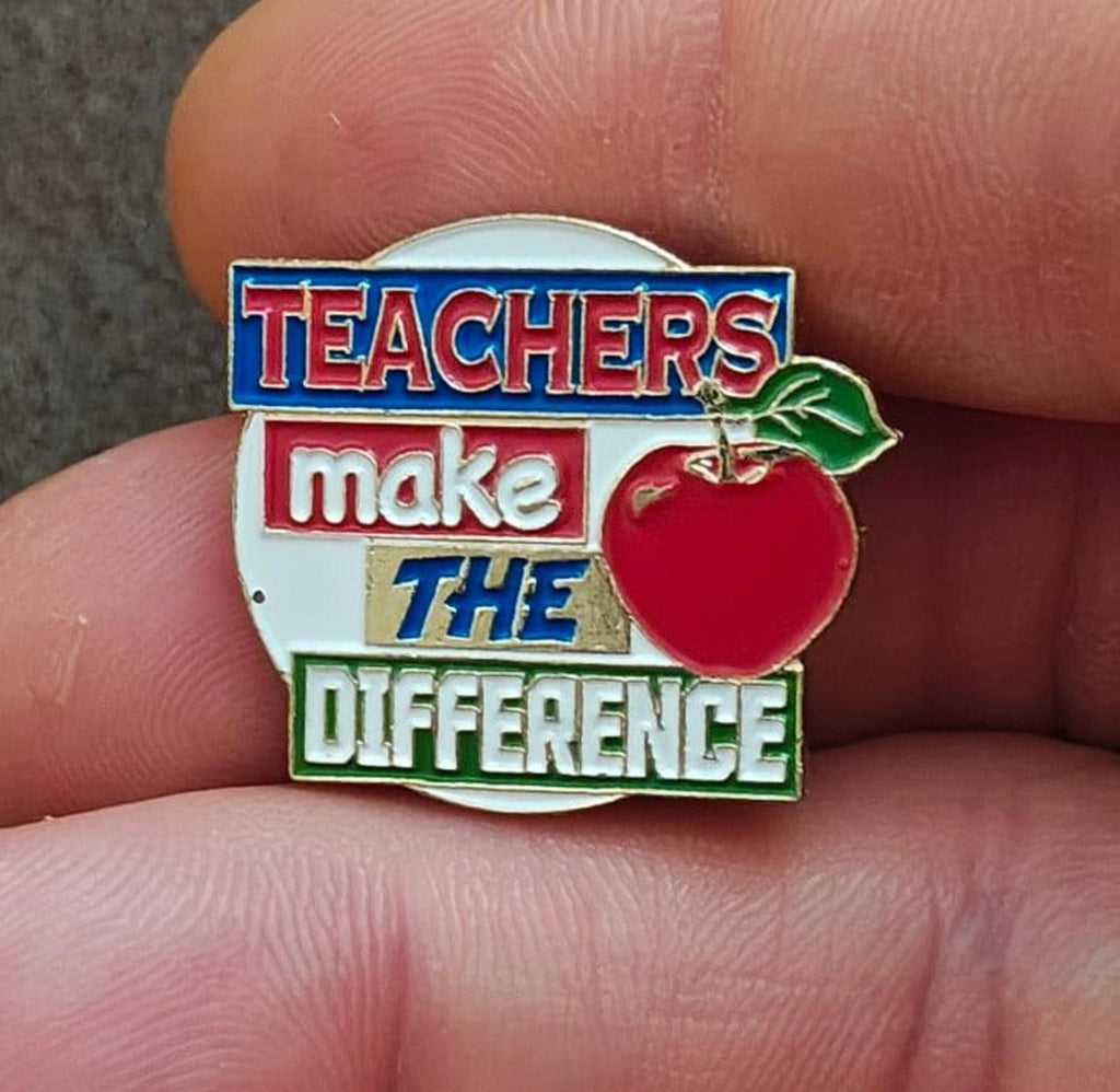 Enamel teacher pin with red apple and slogan “Teachers make the difference”