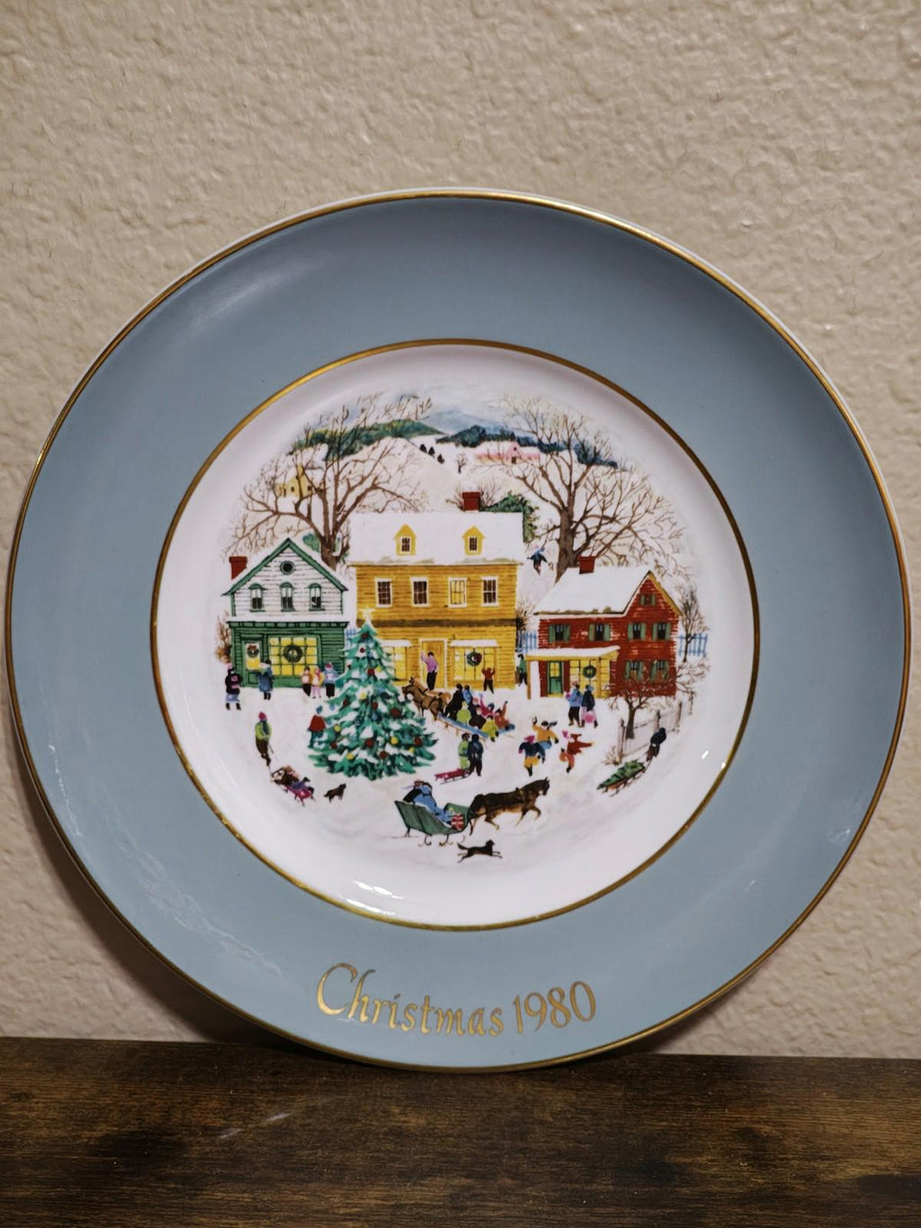 Light blue Avon Country Christmas porcelain plate with 1980 winter village scene and gold rim