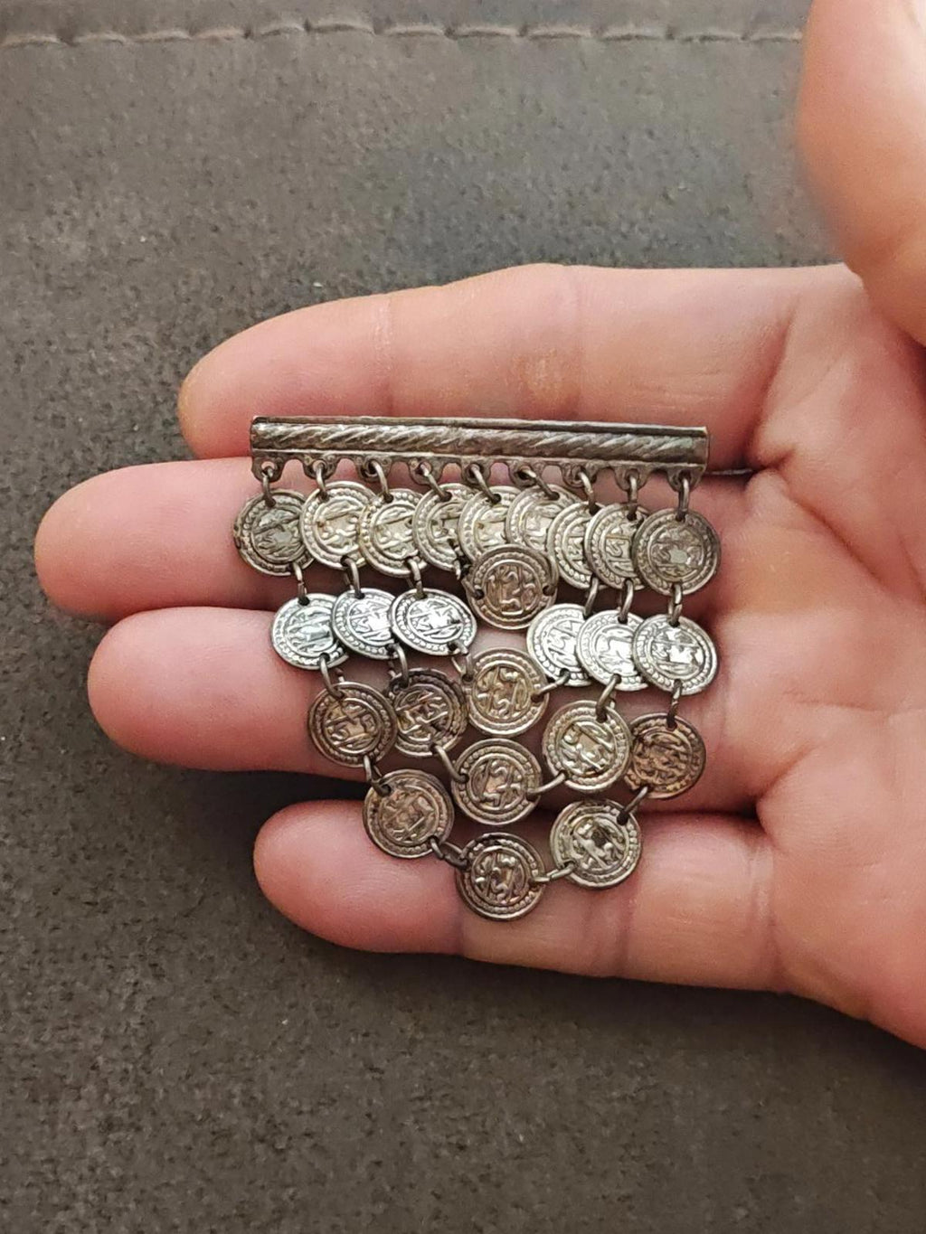 Silver-tone coin dangle brooch with hanging coin charms on a rectangular bar clasp