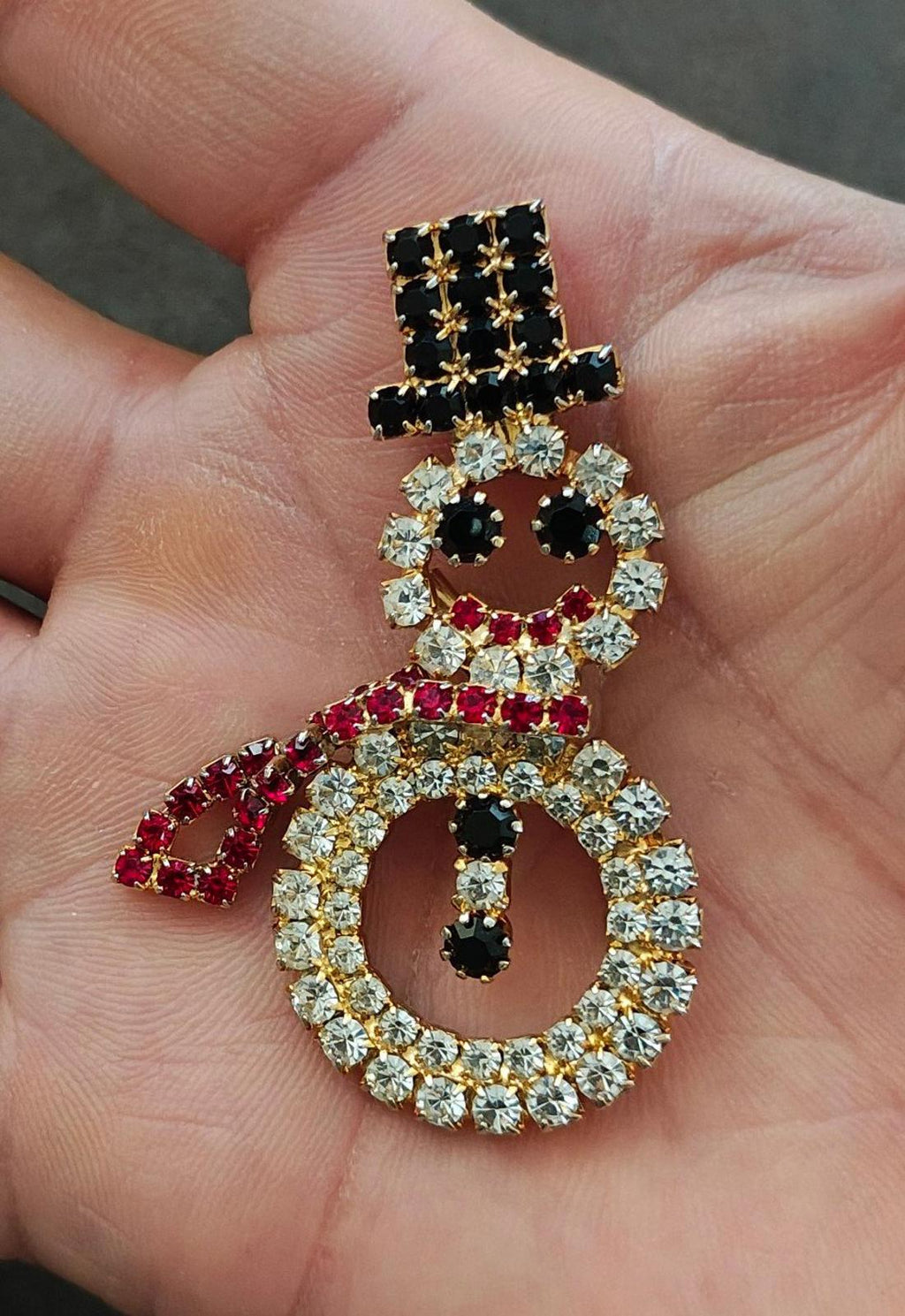 Gold-tone rhinestone snowman brooch with black, red and clear stones, full face and ring