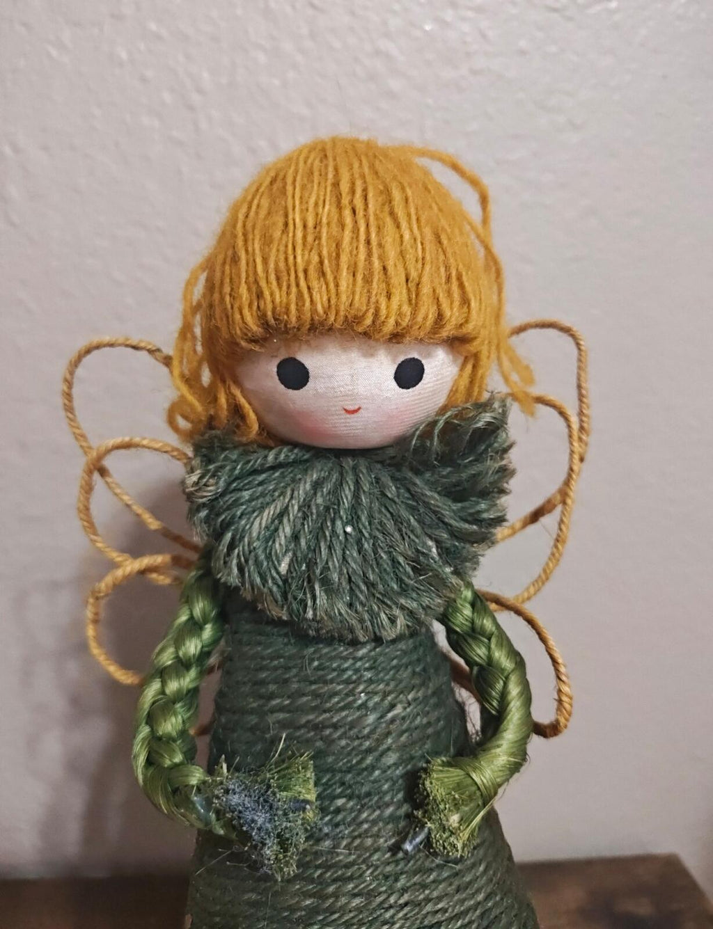 Handcrafted burlap angel tree topper with dark green dress, blond yarn hair, dark fur ruff
