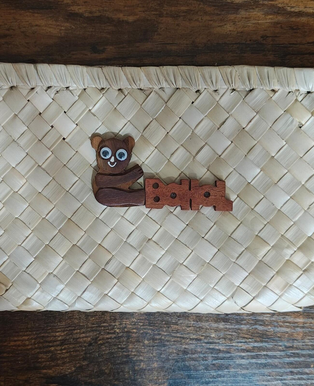 White handwoven pouch close-up of wooden tarsier emblem patch