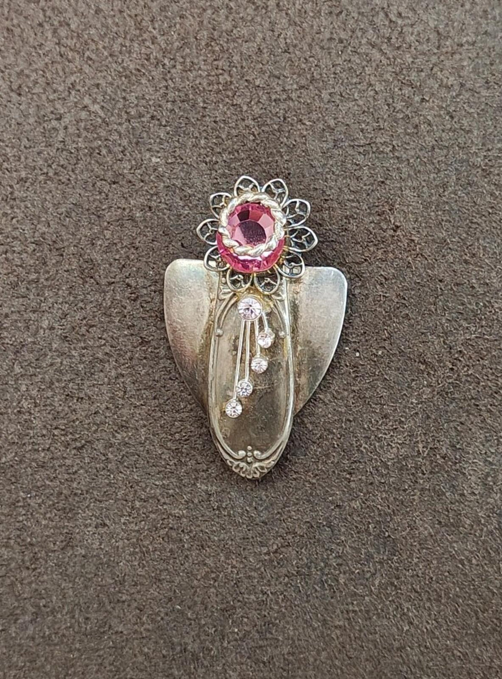 Silver tone angel brooch with ornate filigree, pink center, and dangling rhinestones