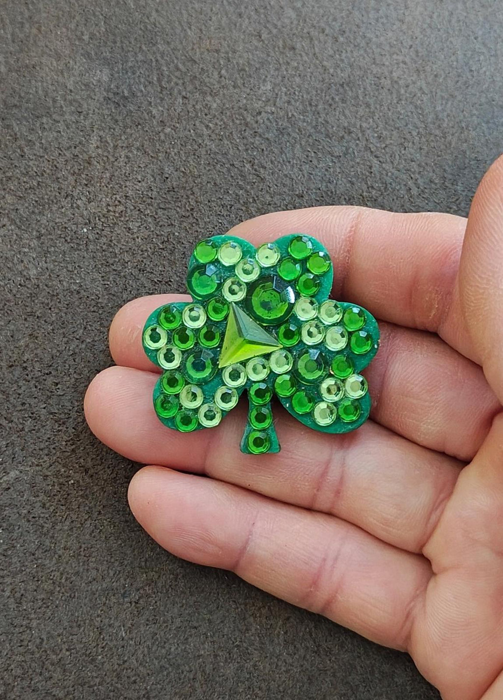 Green rhinestone shamrock brooch pin, close-up with central star-shaped stone