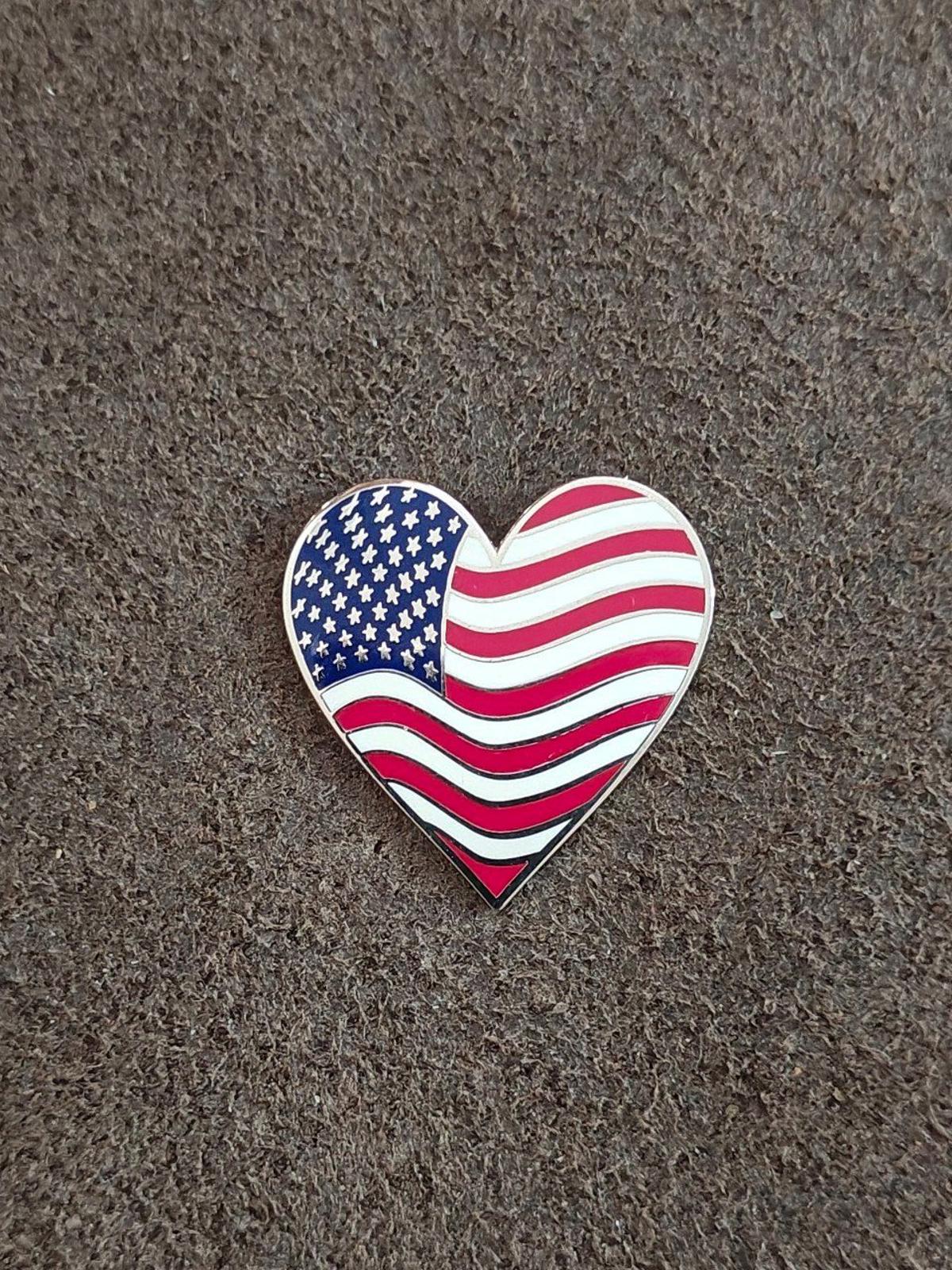 Heart-shaped American flag enamel pin with blue star field and red/white wavy stripes