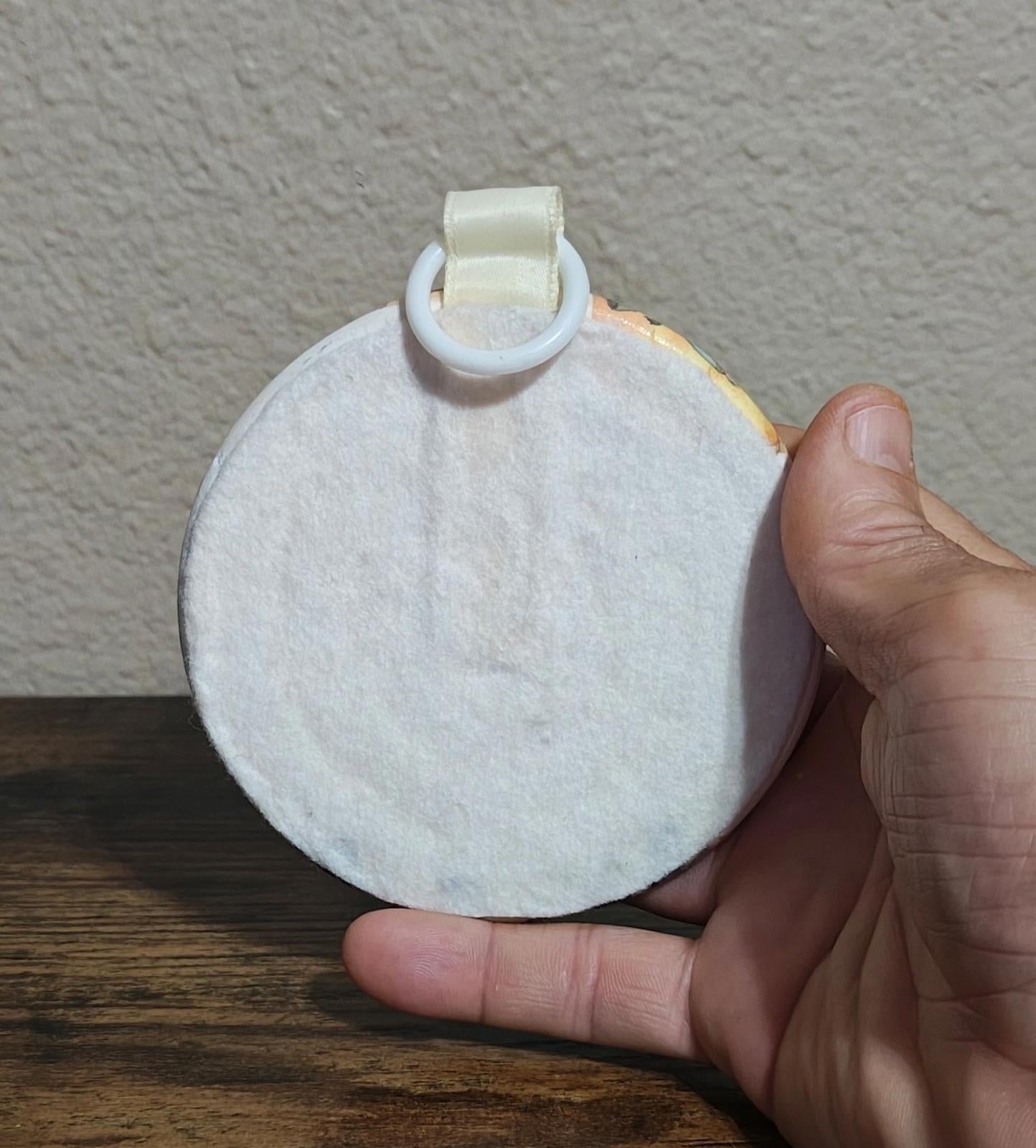 Round ornament back with cream hanging strap and circular loop