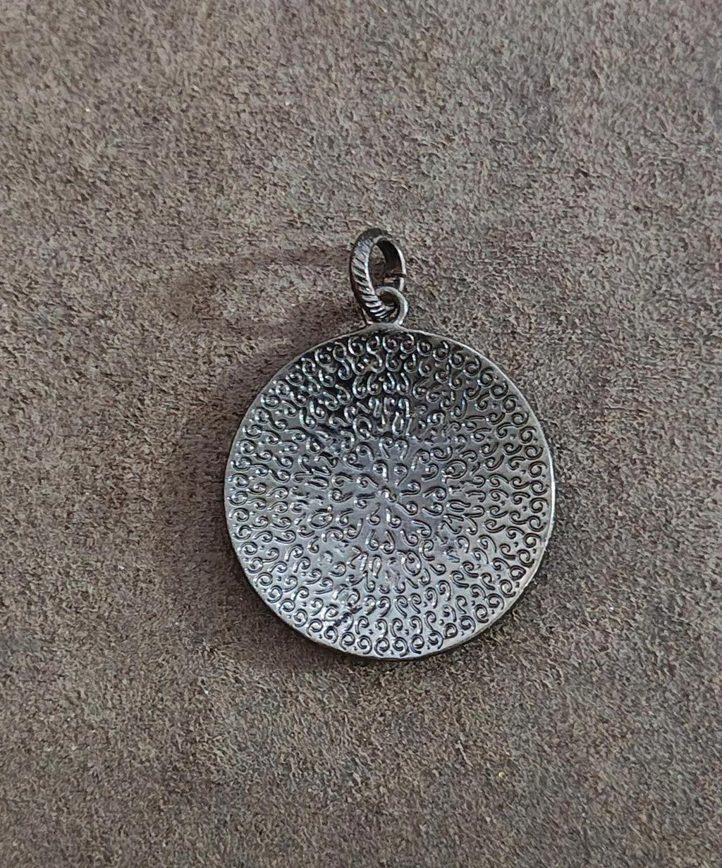 Round gunmetal pendant back with textured floral starburst pattern and loop bail