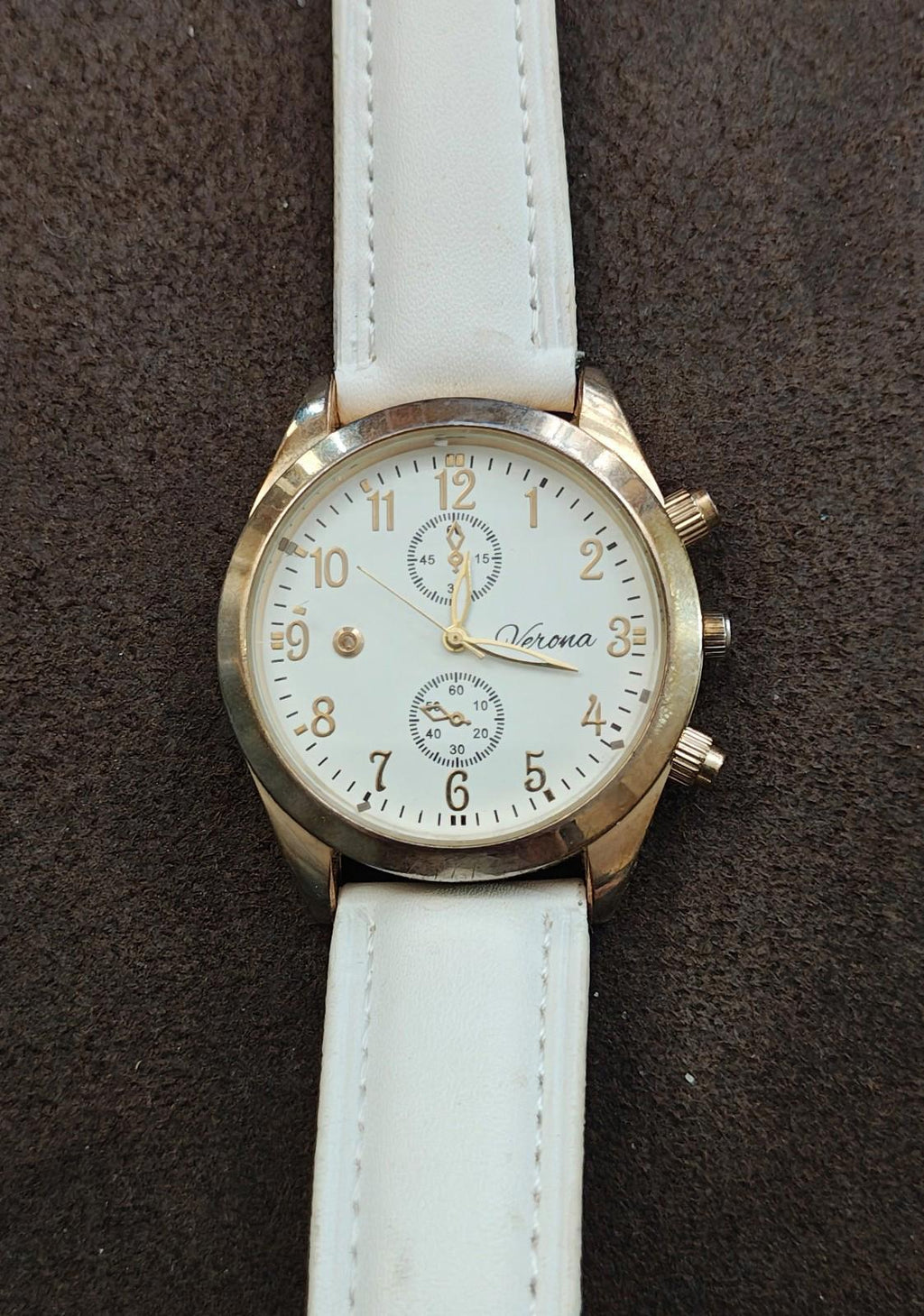 Gold-tone quartz watch front with white dial details and white leather strap