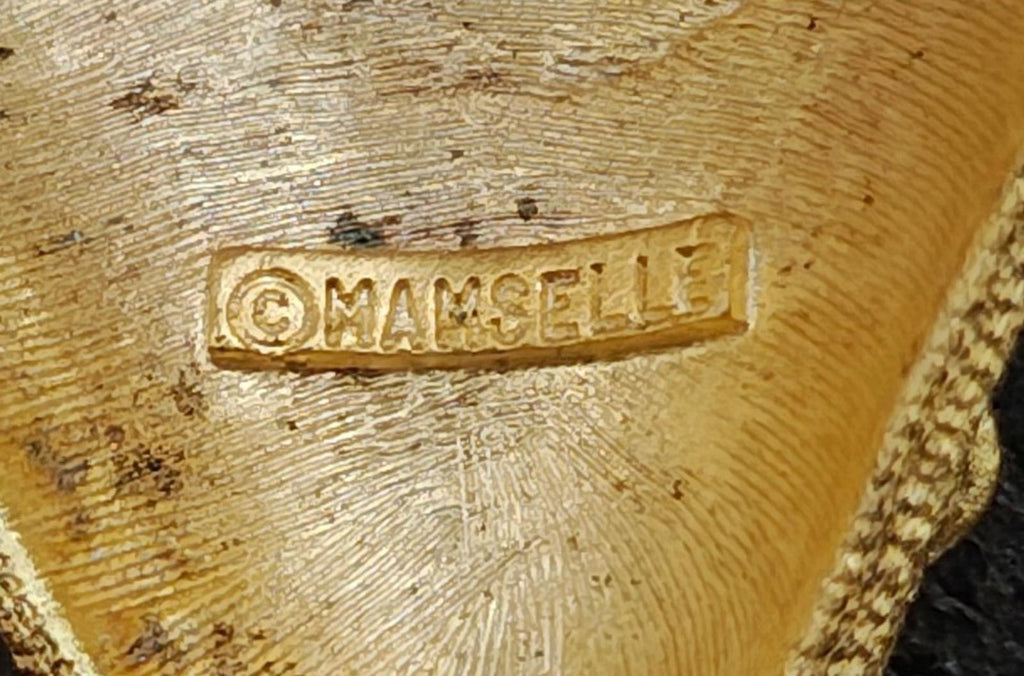 Gold tone Mamselle maker mark stamped on the back of the strawberry brooch pin.