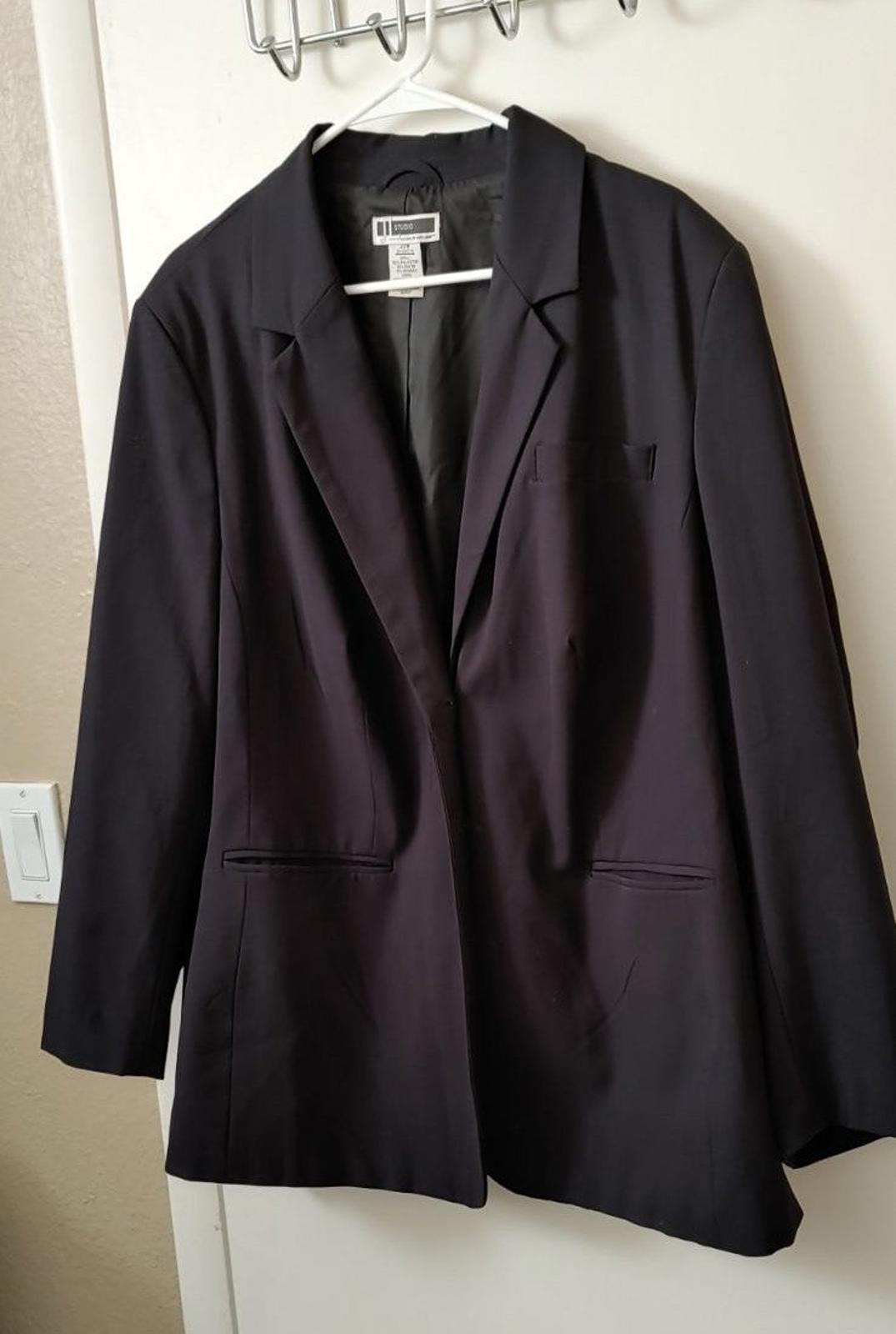 Black blazer with notched lapels and two flap pockets on the front.