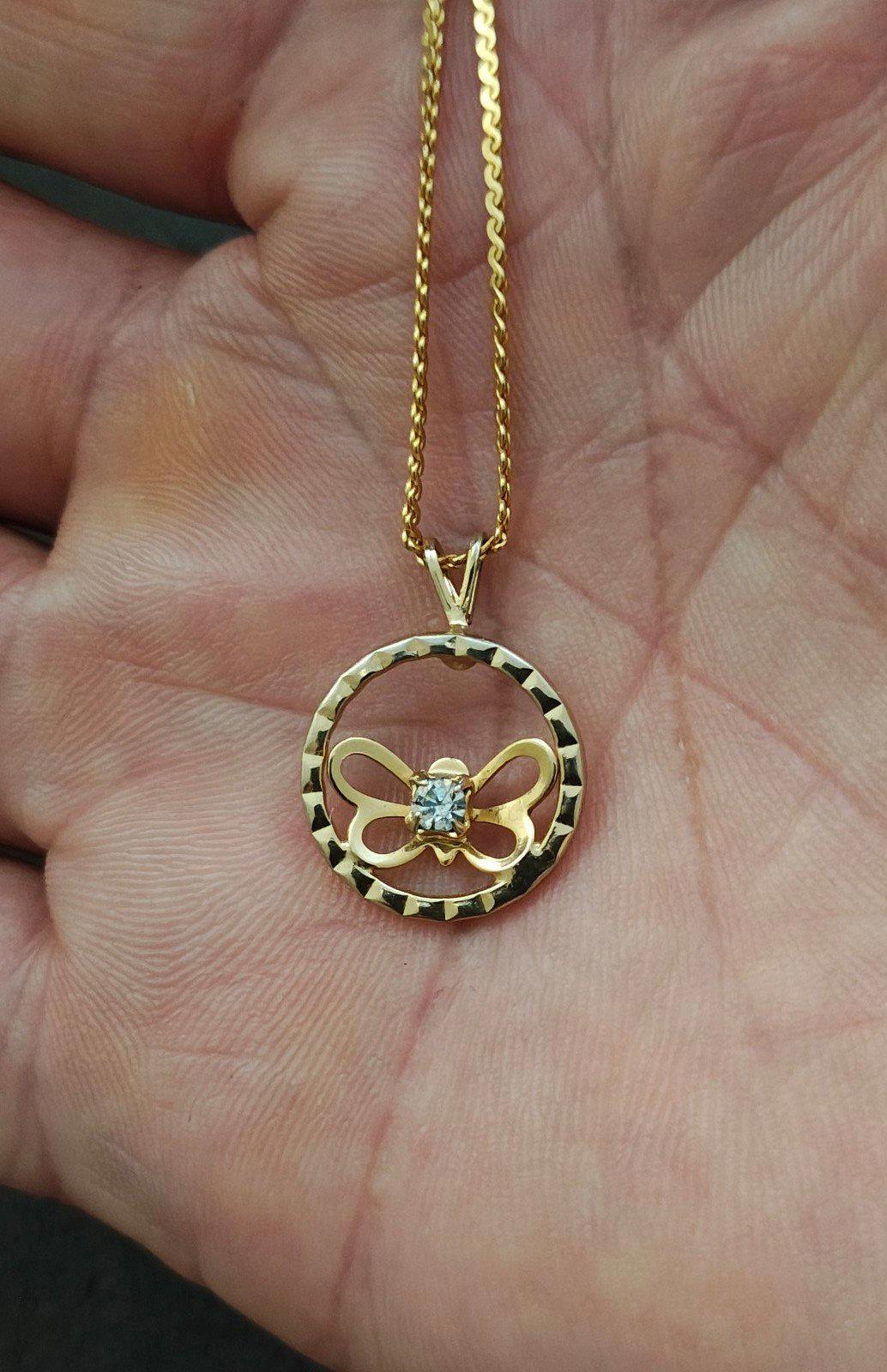 Gold-tone round pendant necklace on chain, open circle design with clear rhinestone butterfly