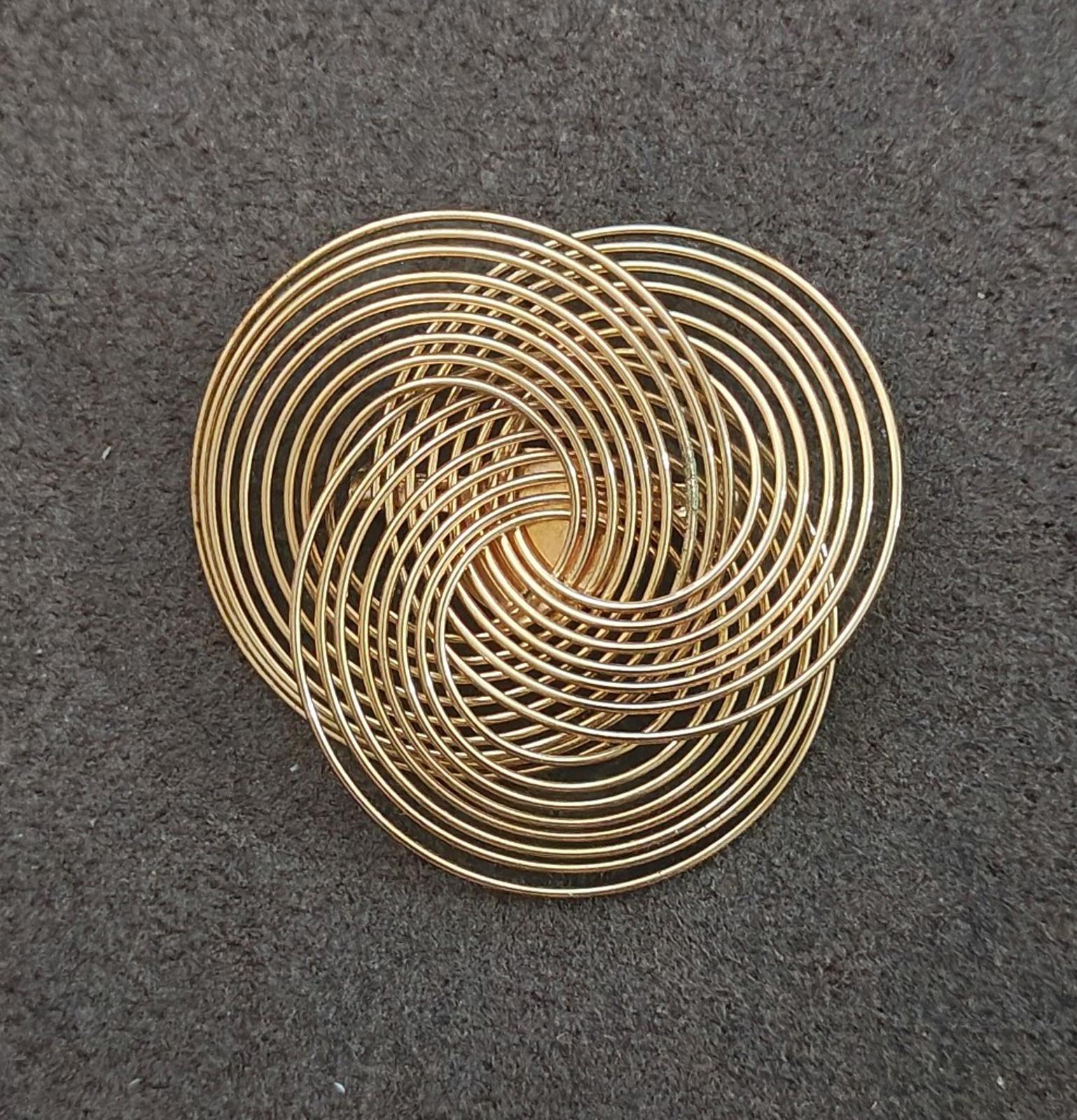 Gold tone wire spiral brooch with layered concentric coils, close top view