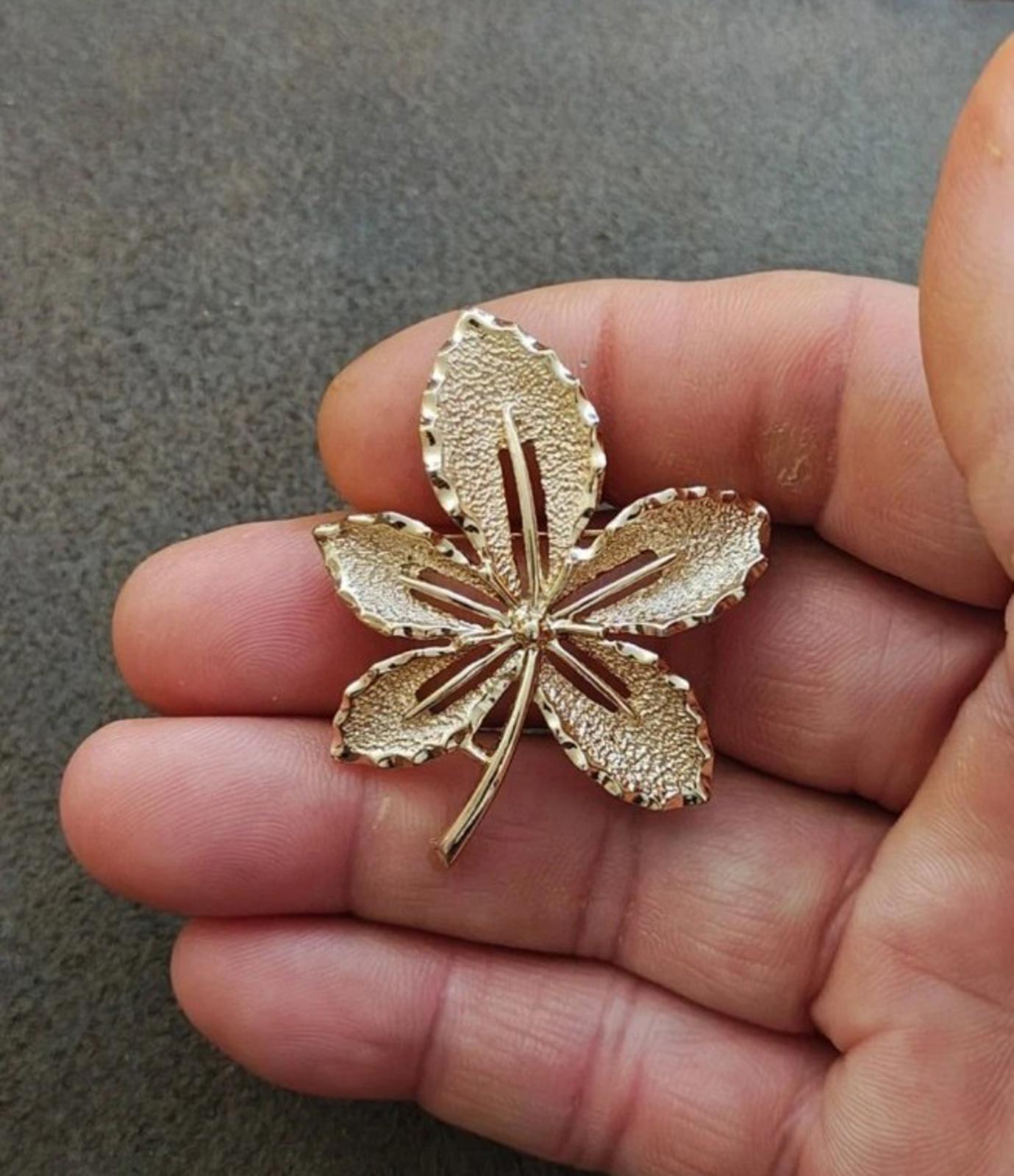 Gold-tone flower brooch with five leaf petals and central vertical detailing