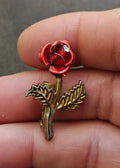 Red enamel rose brooch with clear rhinestone center and gold-tone leaves