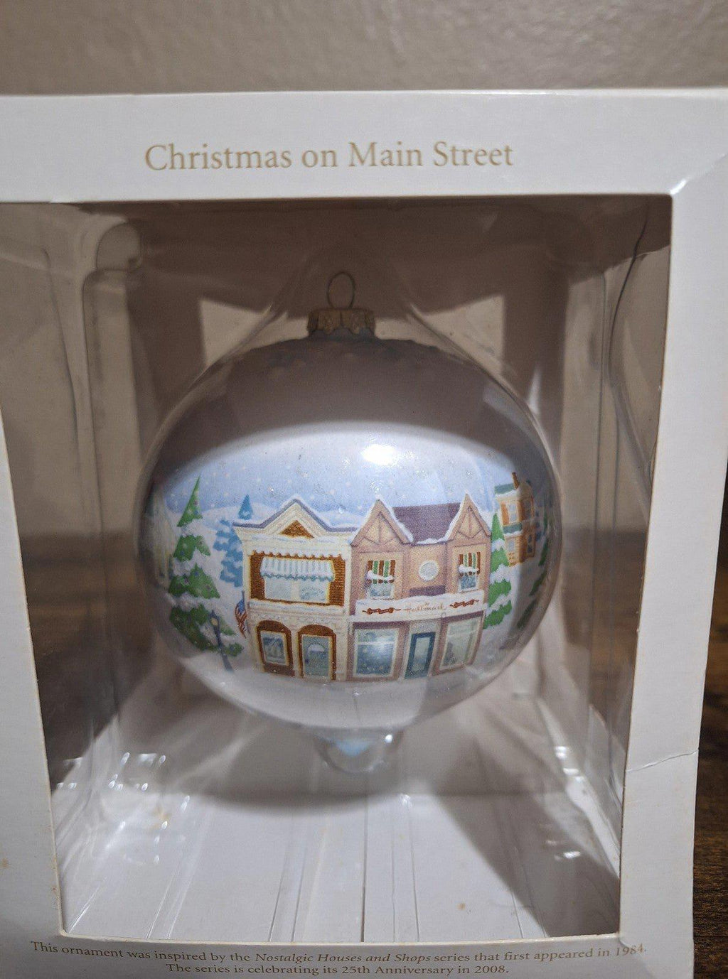 Hallmark Keepsake teardrop ornament featuring snow-covered cottages and trees