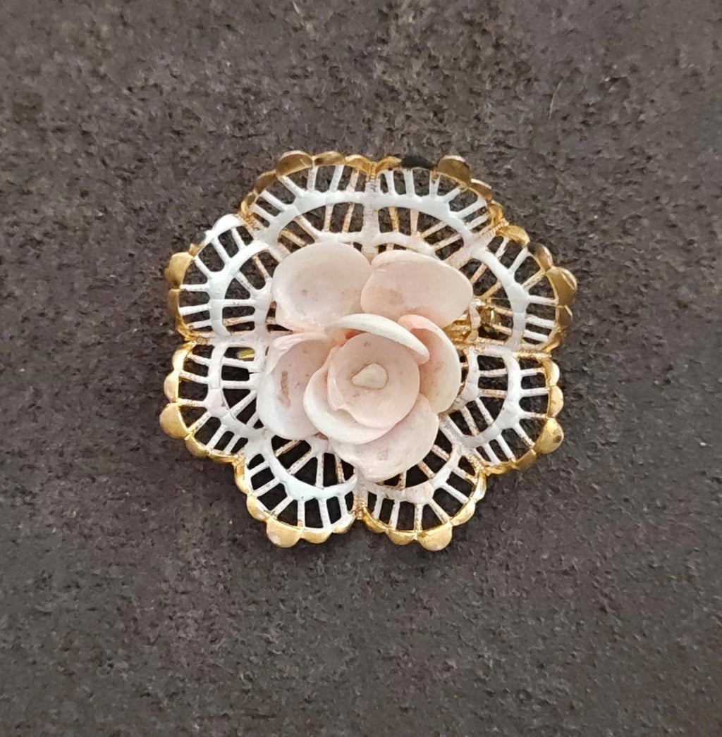 Round gold-tone filigree brooch featuring a white rose with subtle blush centers