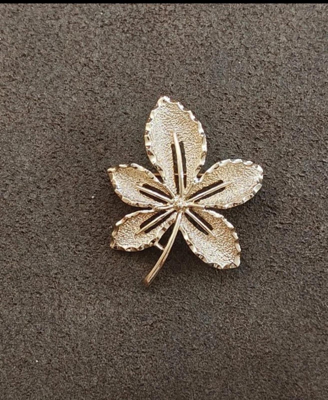 Gold-tone leaf brooch shaped like a five-petal flower, textured surface