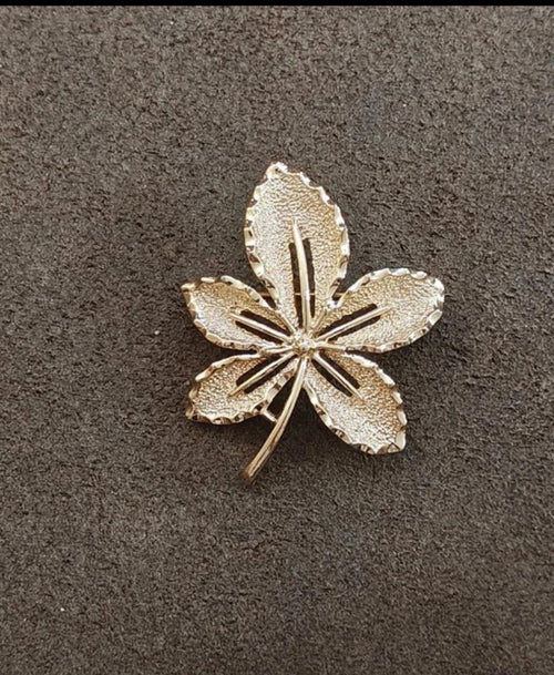 Gold-tone leaf brooch shaped like a five-petal flower, textured surface