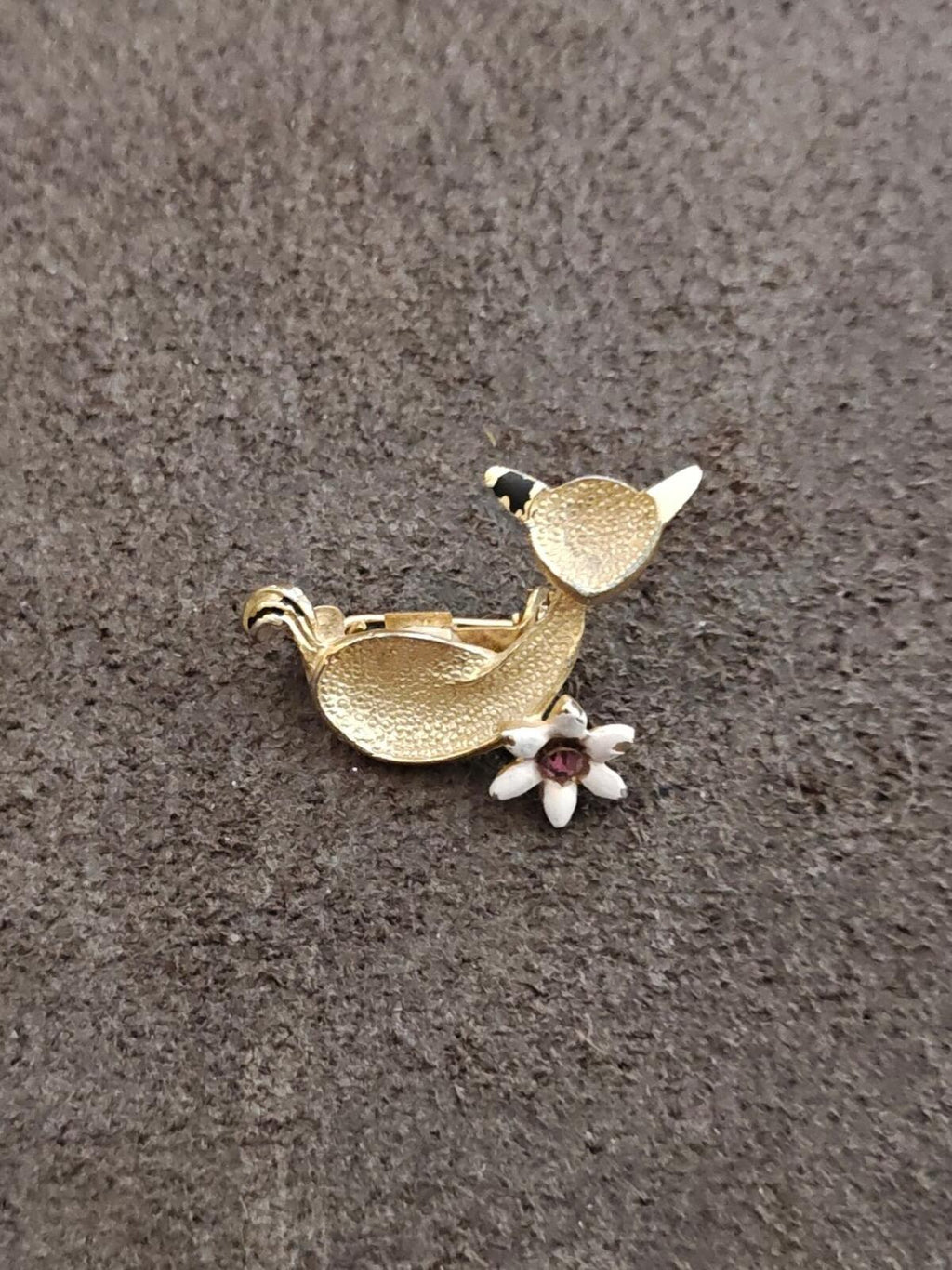 Gold-tone cat brooch with white flower and purple rhinestone center