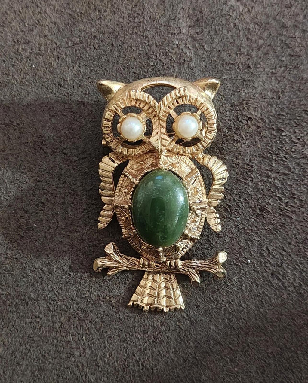 Gold owl brooch with green oval belly stone and faux pearl eyes; detailed layered feathers