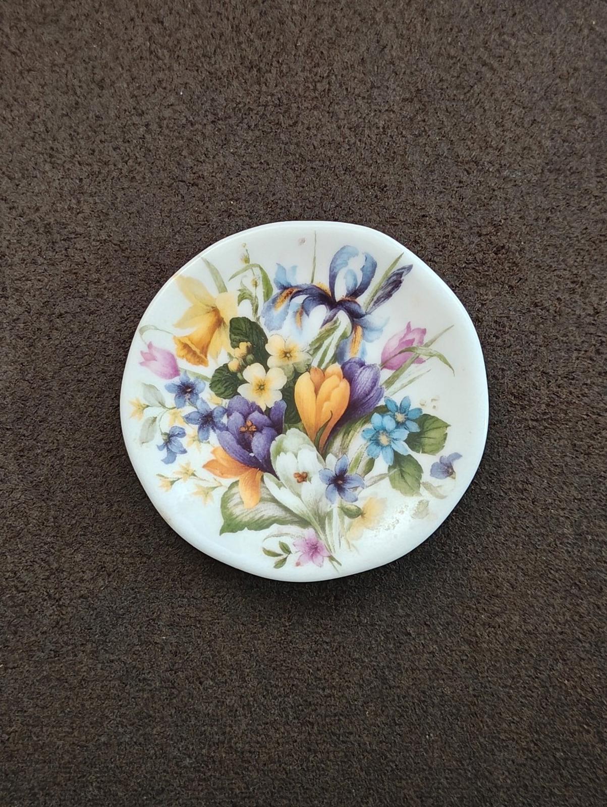 Round miniature decorative plate with mixed wildflower bouquet in blue, yellow, and purple