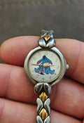 Two-tone bracelet watch with Eeyore character dial and gold-and-silver clasp bow