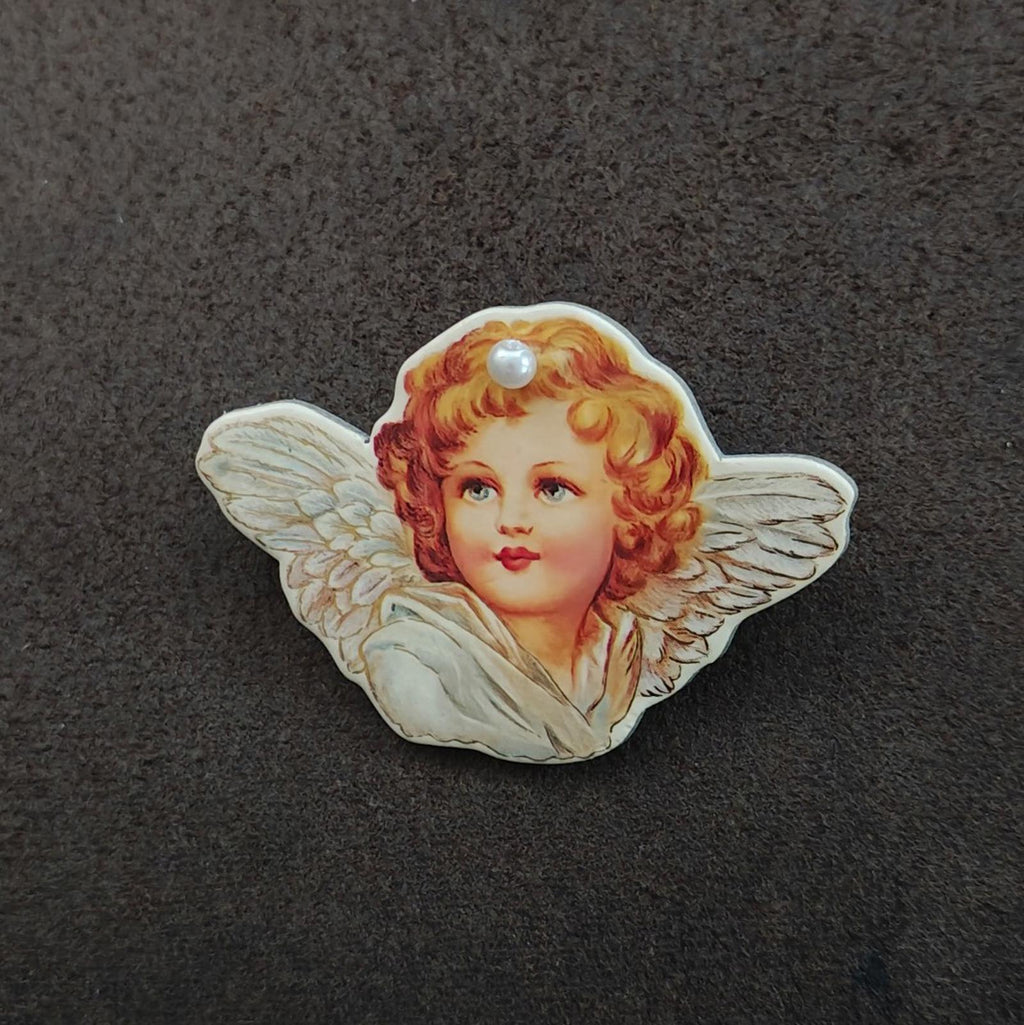 Angel cherub brooch: painted cherub face with pearl at hairline and pale blue wings