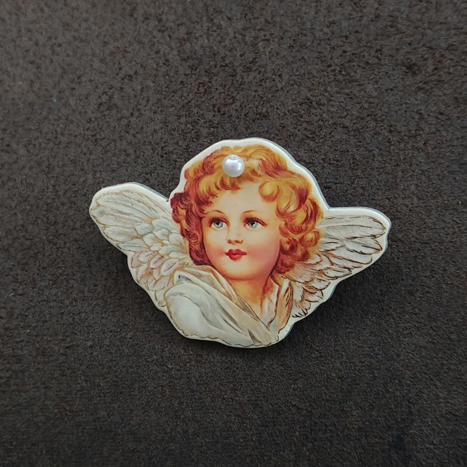 Angel cherub brooch: painted cherub face with pearl at hairline and pale blue wings