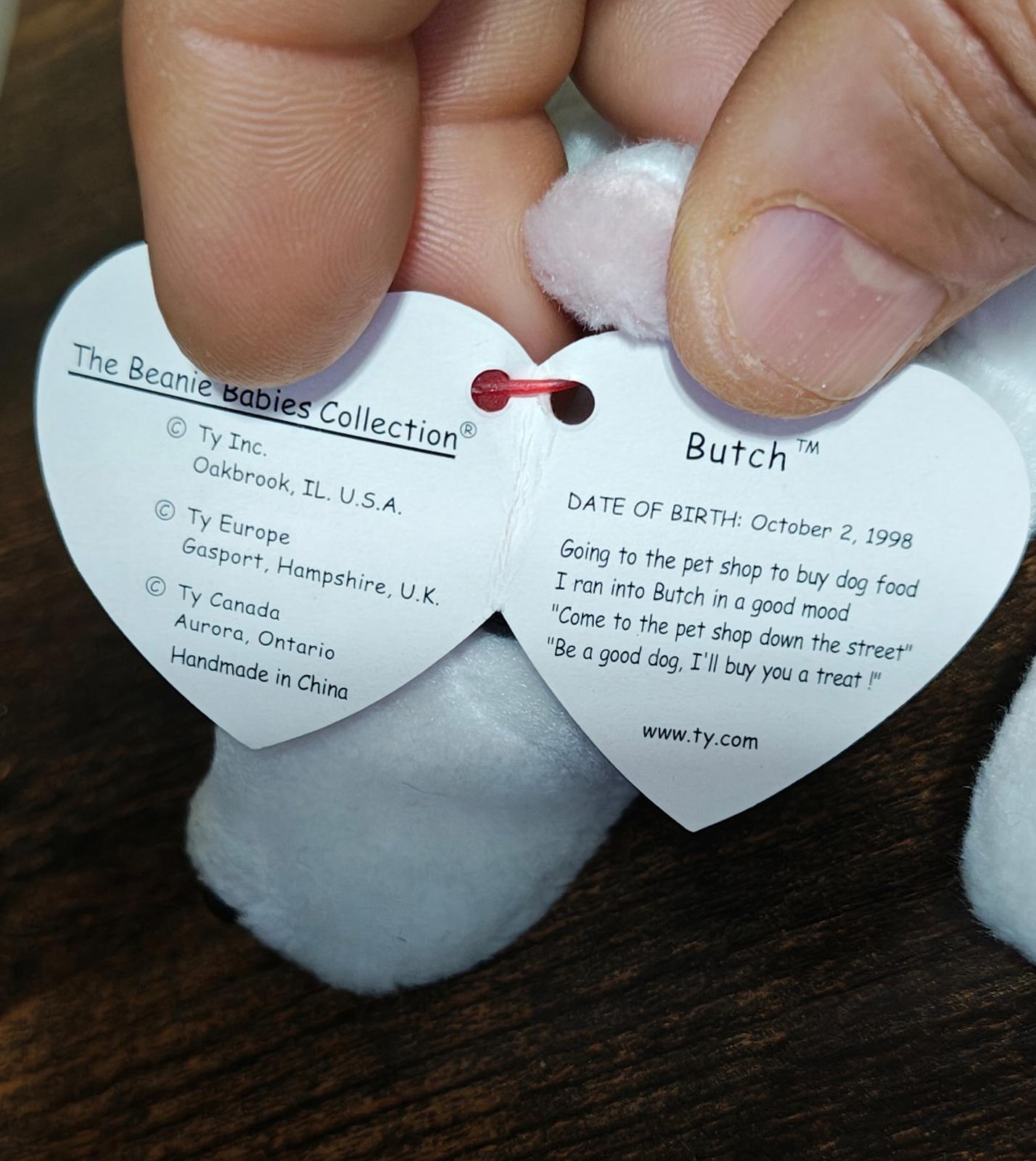 White plush dog tags with printed text and date on heart-shaped tag
