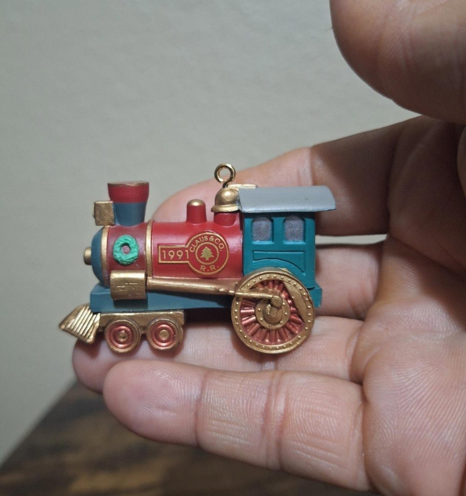 Blue and red train locomotive ornament with gold trim, spinning wheel detail, hanging loop