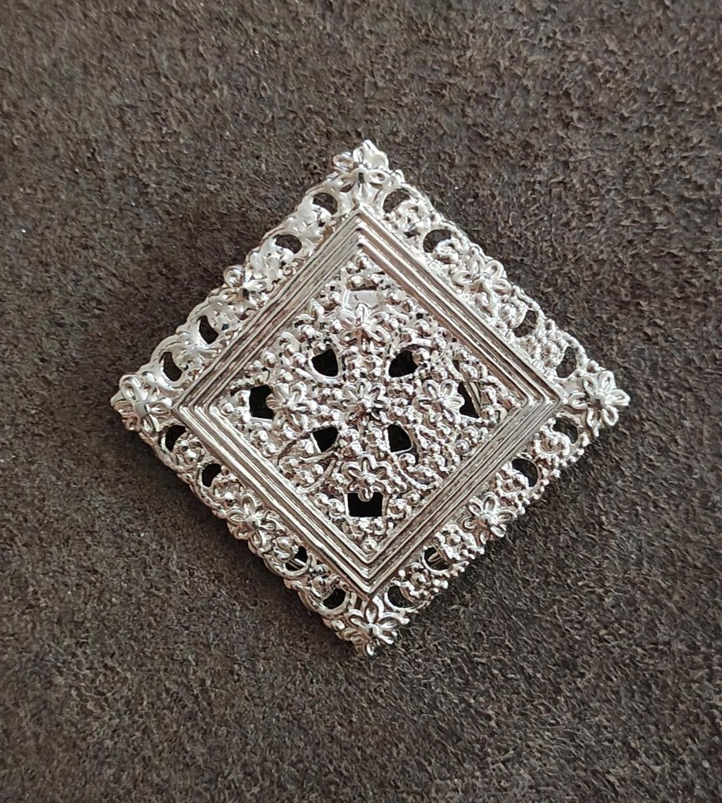 Silver-tone square filigree scarf clip with ornate border and open floral cutouts