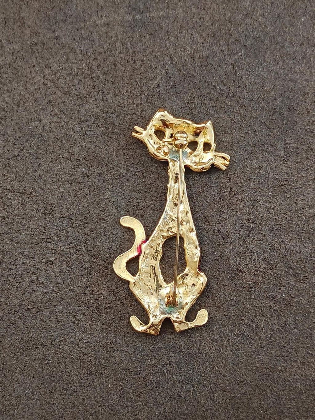 Gold-tone cat mask brooch back view with pin clasp and textured frame.