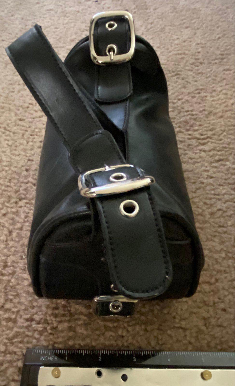Black leather purse with adjustable strap and metal buckle detail at top