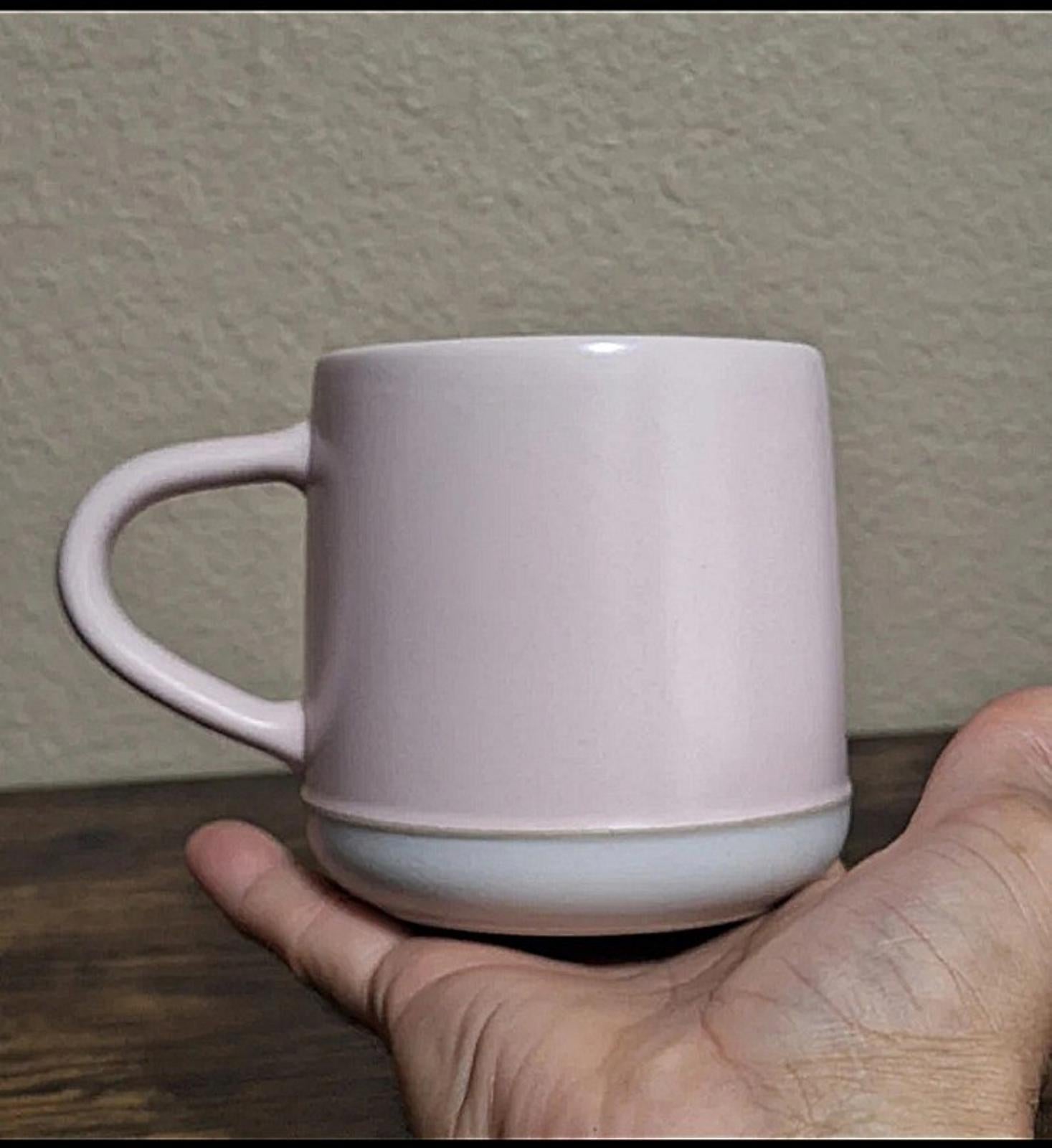Pink stoneware mug with curved handle and plain front panel