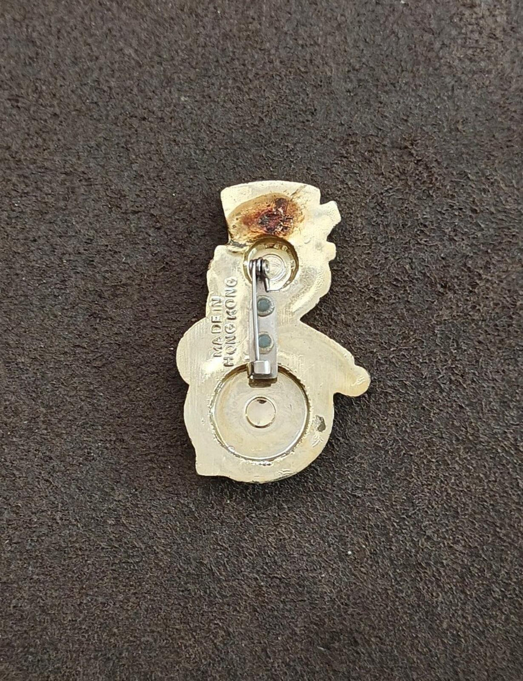 Back of enamel snowman brooch with safety pin clasp and gold-tone finish