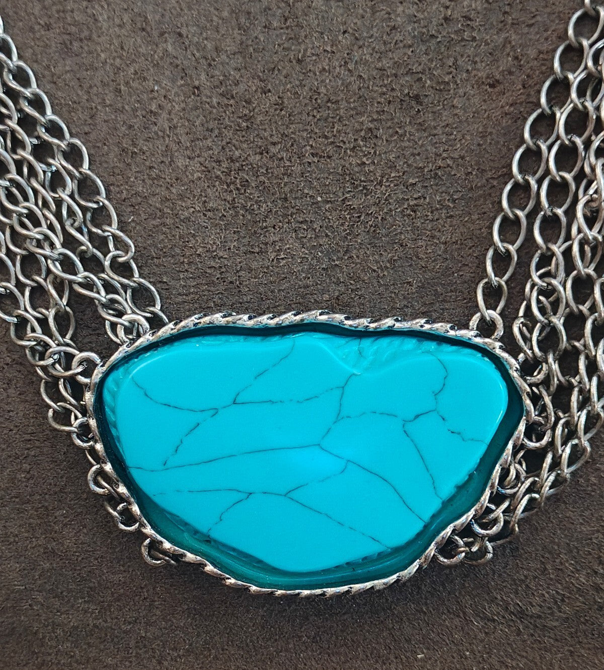 Silver Tone Multi Strand Chain Statement Necklace With a Faux Turquoise Stone