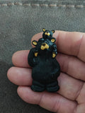 Black bear and baby bear plastic pin, standing together with yellow faces and ears