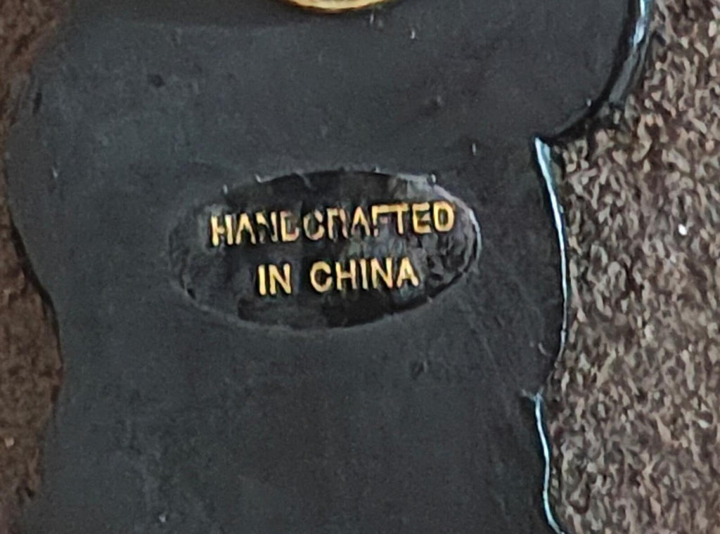 Black bear pin back stamp reading "HANDCRAFTED IN CHINA" in gold letters