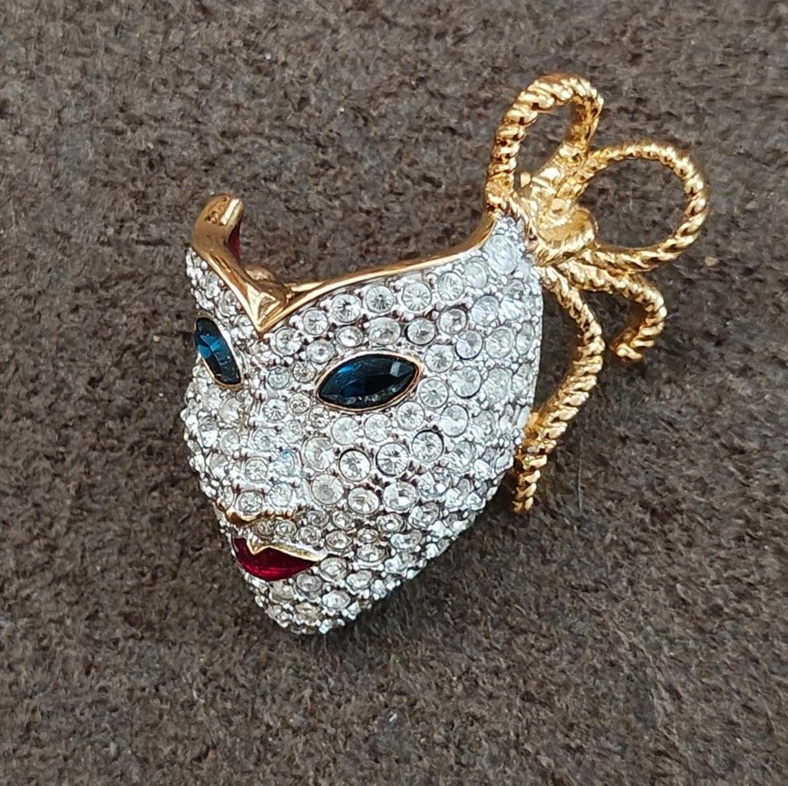 Swarovski Mardi Gras masquerade mask brooch with clear crystals, blue eyes, and gold bow