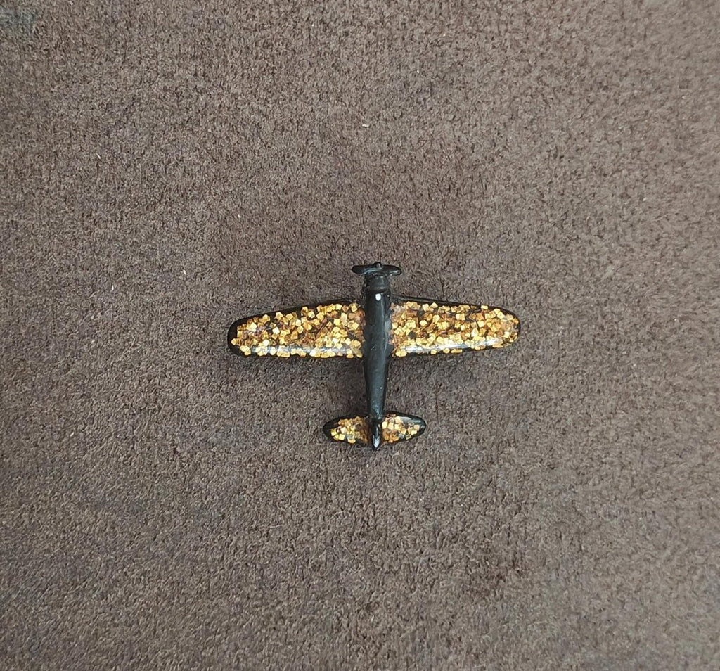 Gold glitter airplane brooch with dark wings and center post detail
