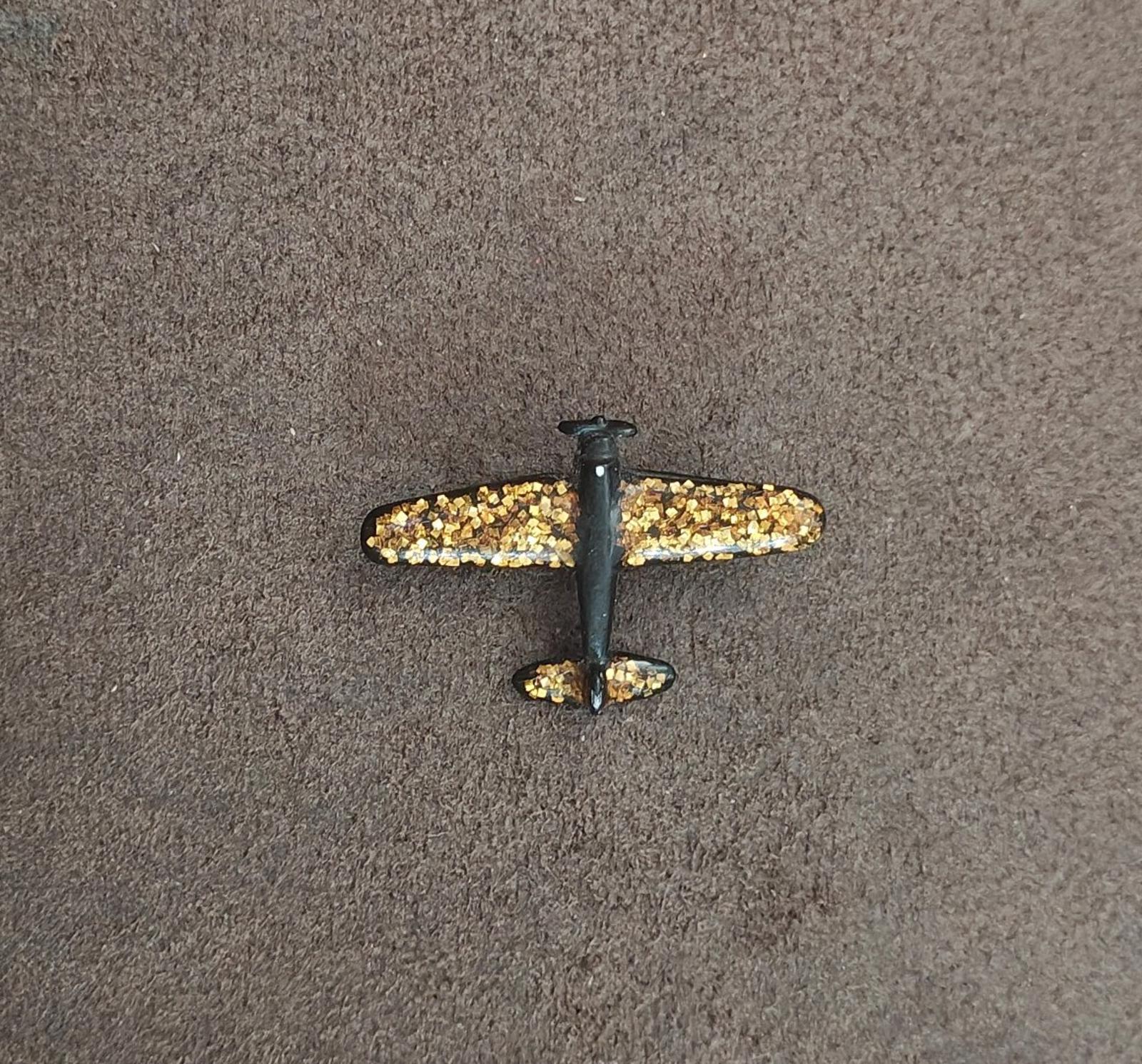 Gold glitter airplane brooch with dark wings and center post detail
